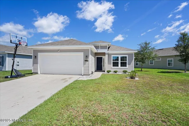 a front view of a house with a yard and garage