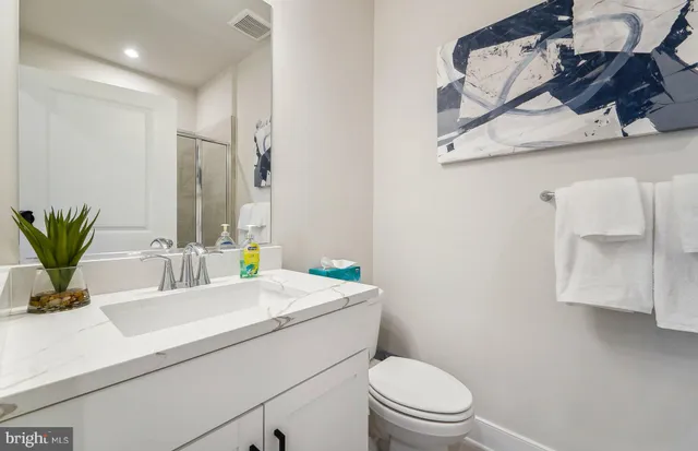 a bathroom with a sink a toilet and mirror