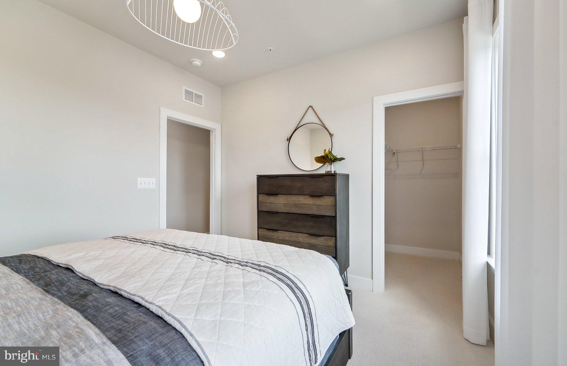 14406 Dowitcher Way Boyds, MD 20841 - Photo 30 of 52 a bedroom with a bed and a chandelier