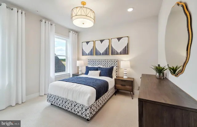 a bedroom with a bed and dresser with wooden floor