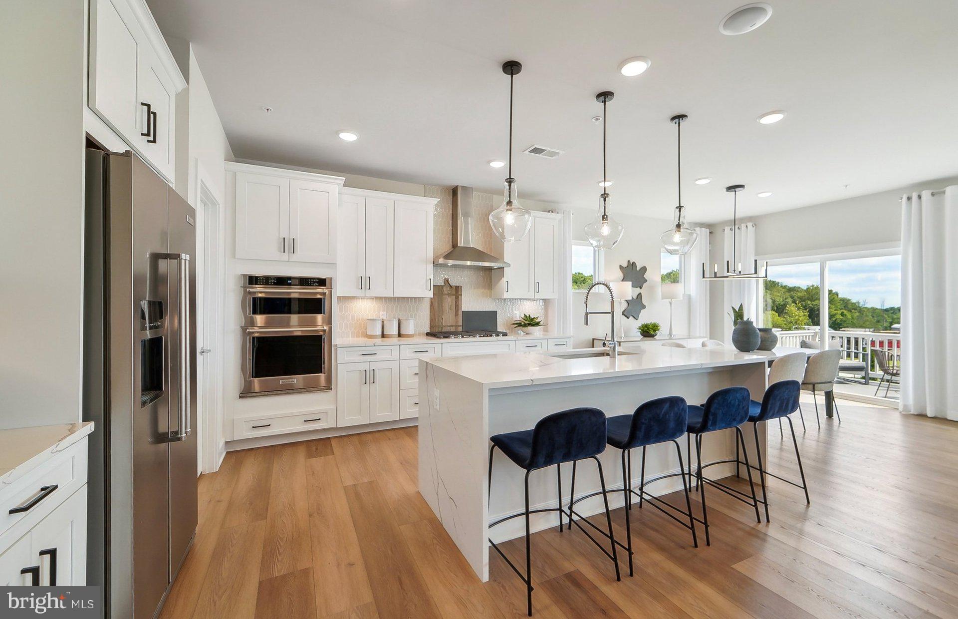 14406 Dowitcher Way Boyds, MD 20841 - Photo 8 of 52 a kitchen with stainless steel appliances granite countertop a stove a refrigerator a oven a sink with a dining table and chairs