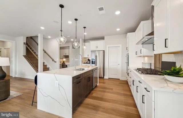 a large kitchen with stainless steel appliances kitchen island granite countertop a large center island attached withe living room