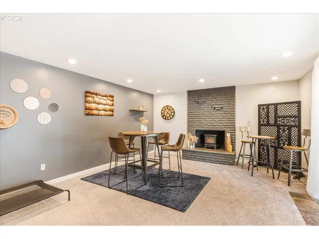a living room with furniture a fireplace and a dining table with wooden floor