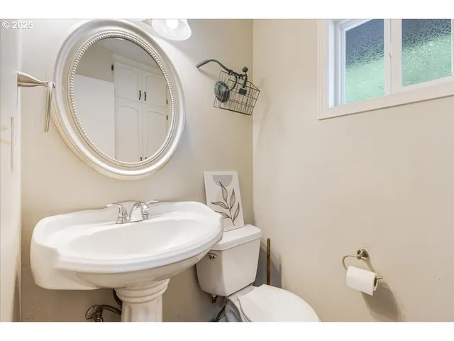 a bathroom with a sink a toilet and a mirror