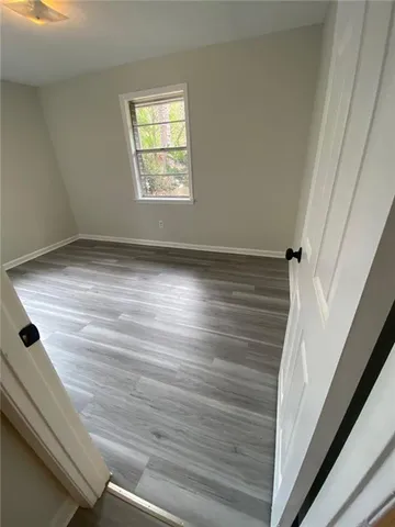 a view of empty room with window and wooden floor