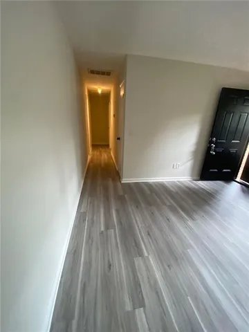a view of empty room with wooden floor