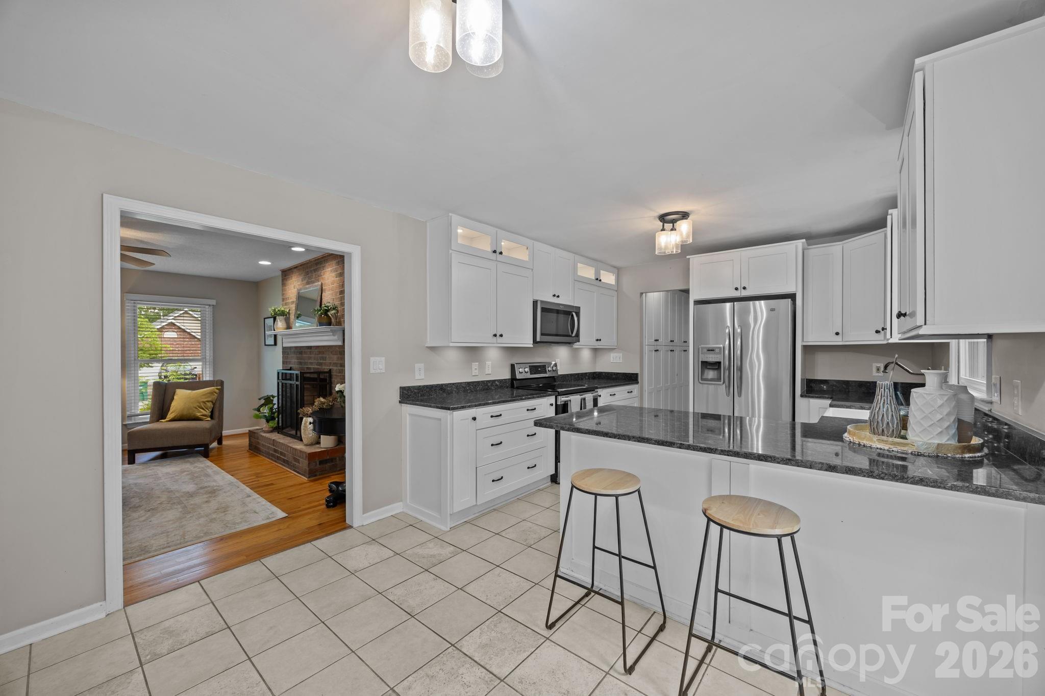 6 Springfield Way Arden, NC 28704 - Photo 15 of 47 a kitchen with stainless steel appliances kitchen island granite countertop a refrigerator and cabinets