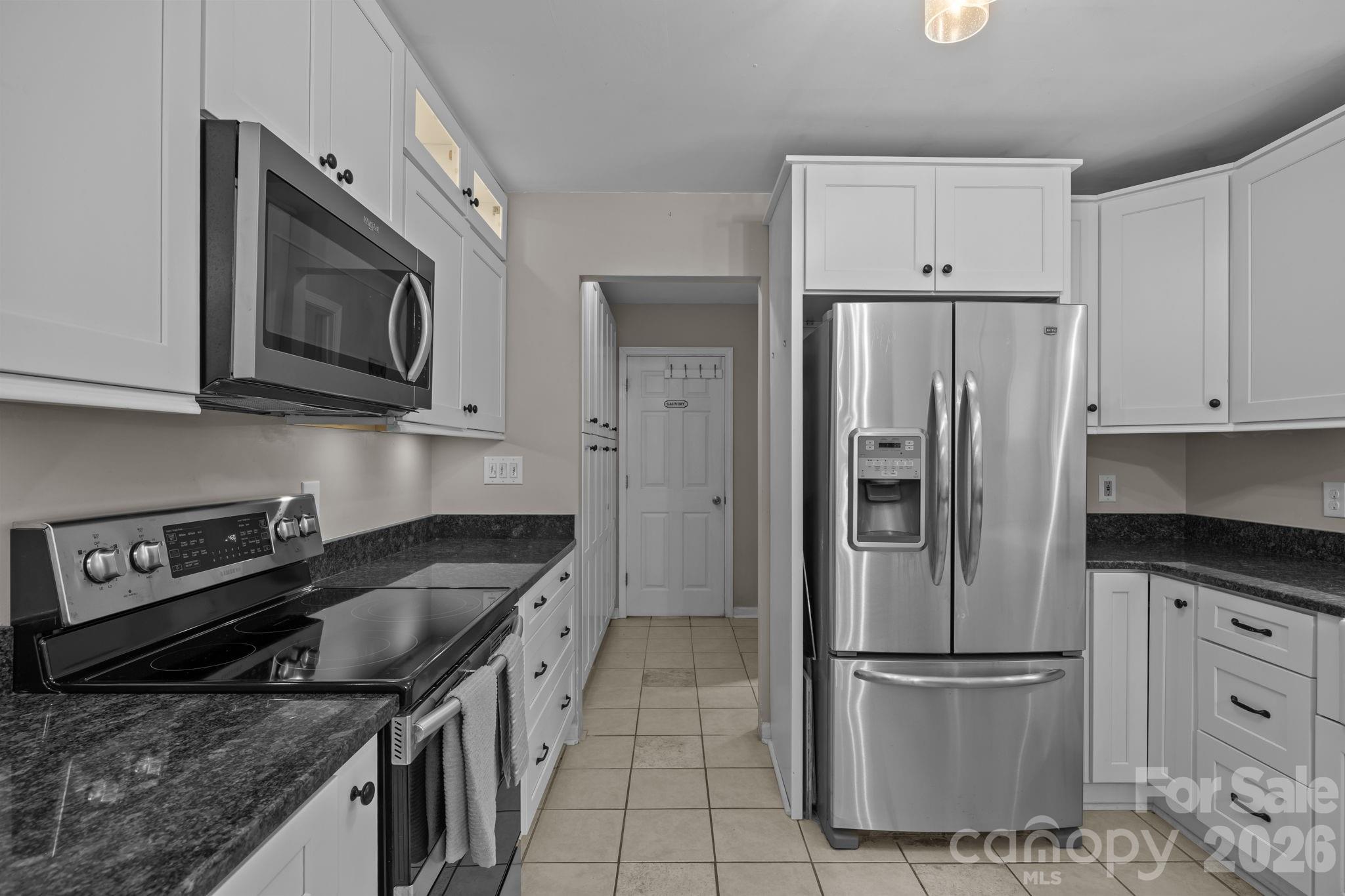 6 Springfield Way Arden, NC 28704 - Photo 16 of 47 a kitchen with stainless steel appliances granite countertop a stove a refrigerator and a microwave