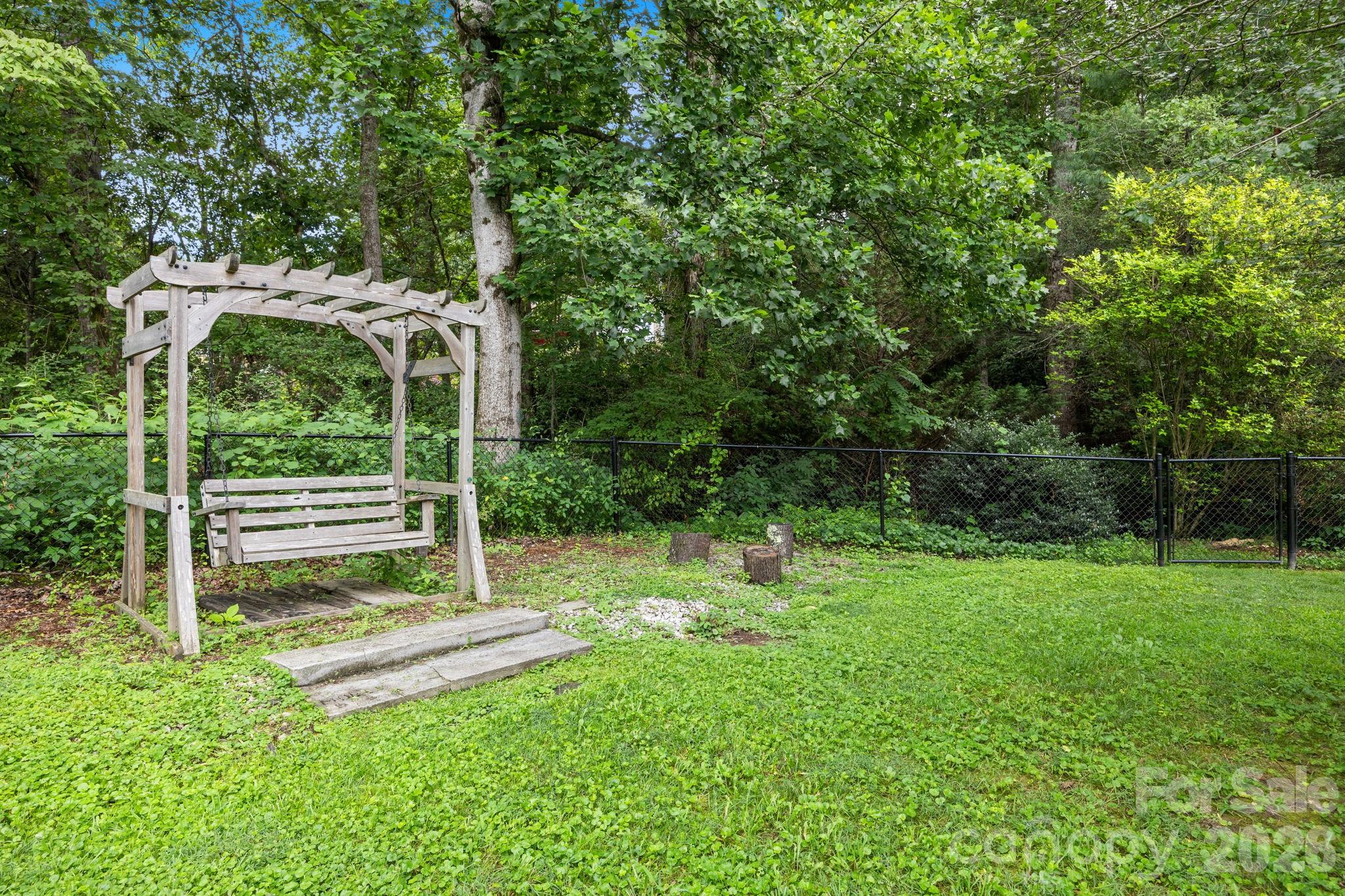 6 Springfield Way Arden, NC 28704 - Photo 38 of 47 a backyard of a house with plants and wooden fence