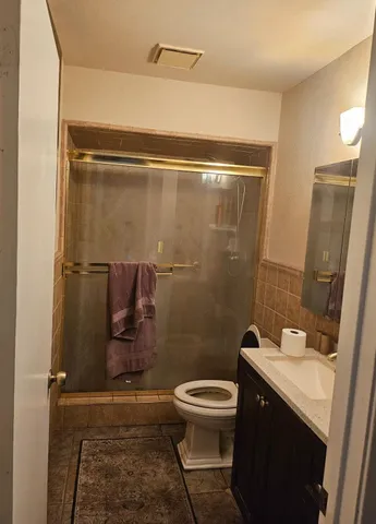 a bathroom with a sink a toilet a mirror and shower