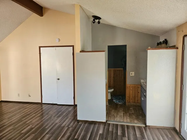 a view of a hallway with wooden floor and closet