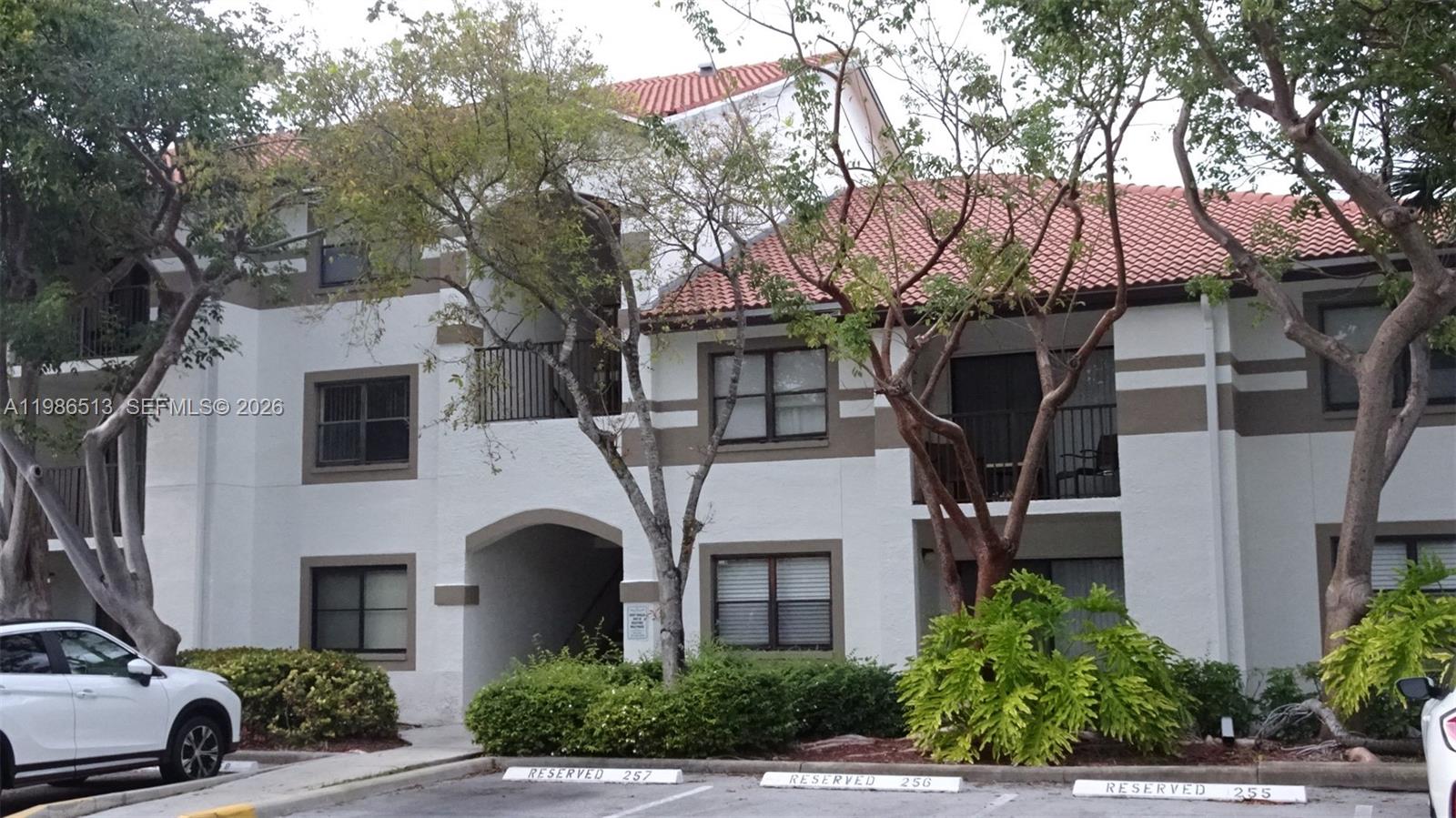 a front view of a house with yard and parking