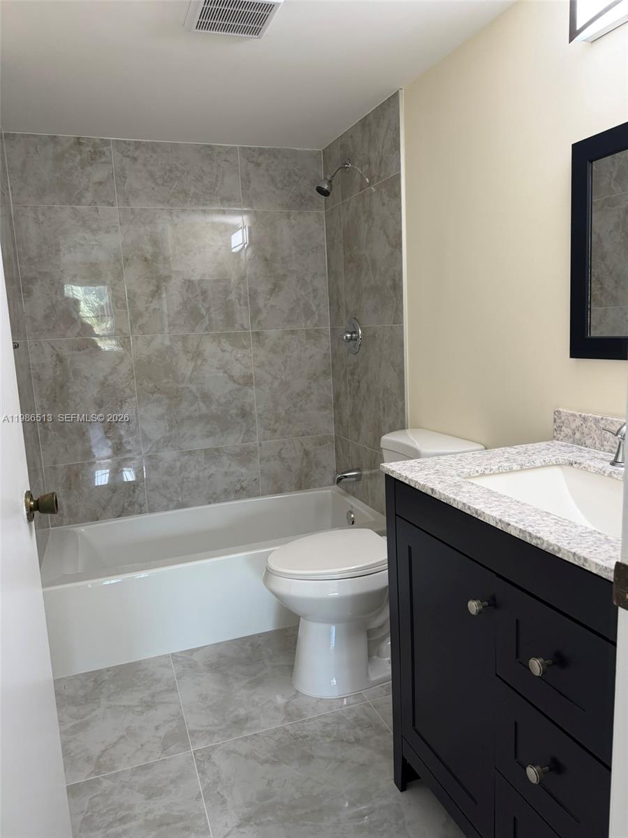 560 South Park Road, Unit 367 Hollywood, FL 33021 - Photo 15 of 28 a bathroom with a granite countertop toilet a sink and bathtub