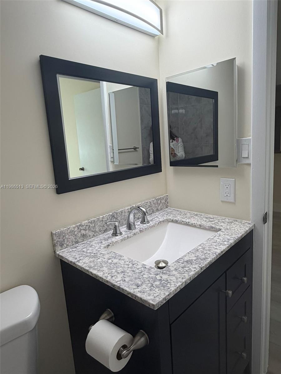 560 South Park Road, Unit 367 Hollywood, FL 33021 - Photo 18 of 28 a bathroom with a granite countertop sink and a toilet
