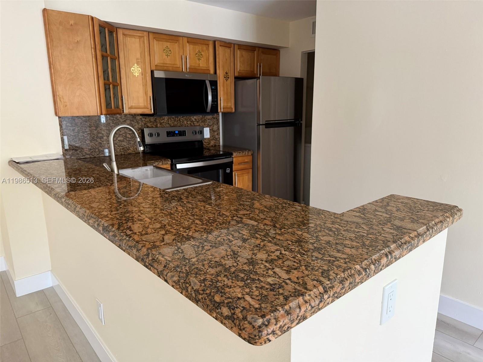 560 South Park Road, Unit 367 Hollywood, FL 33021 - Photo 3 of 28 a kitchen with stainless steel appliances granite countertop a sink refrigerator and microwave