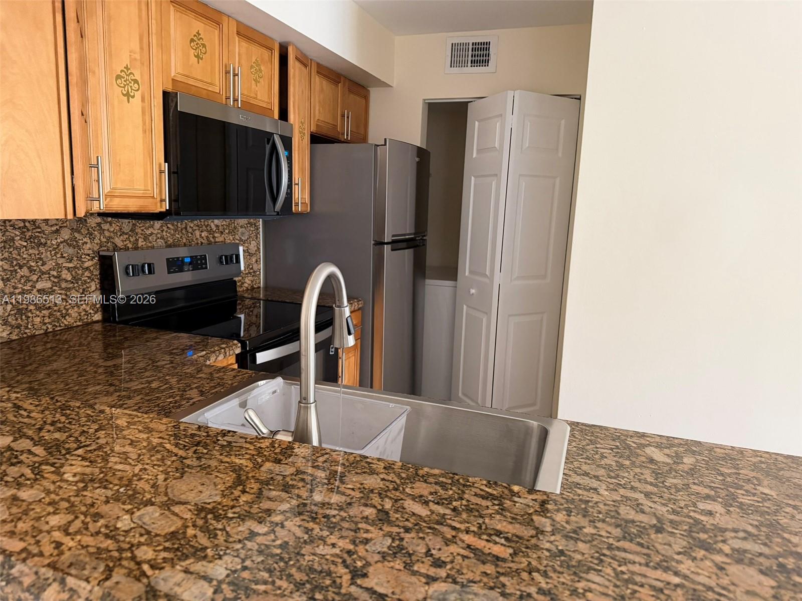 560 South Park Road, Unit 367 Hollywood, FL 33021 - Photo 4 of 28 a kitchen with granite countertop a refrigerator and a sink