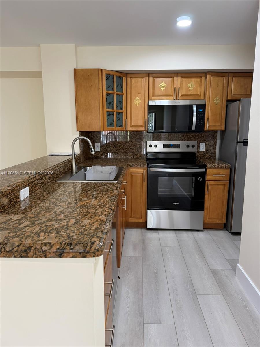 560 South Park Road, Unit 367 Hollywood, FL 33021 - Photo 5 of 28 a kitchen with stainless steel appliances granite countertop a stove refrigerator and microwave