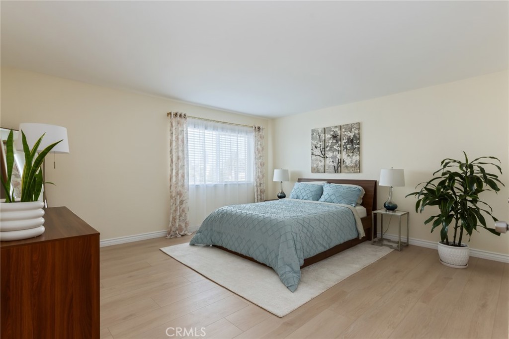726 Elm Avenue, Unit 404 Long Beach, CA 90813 - Photo 24 of 31 a bedroom with a large bed and a potted plant