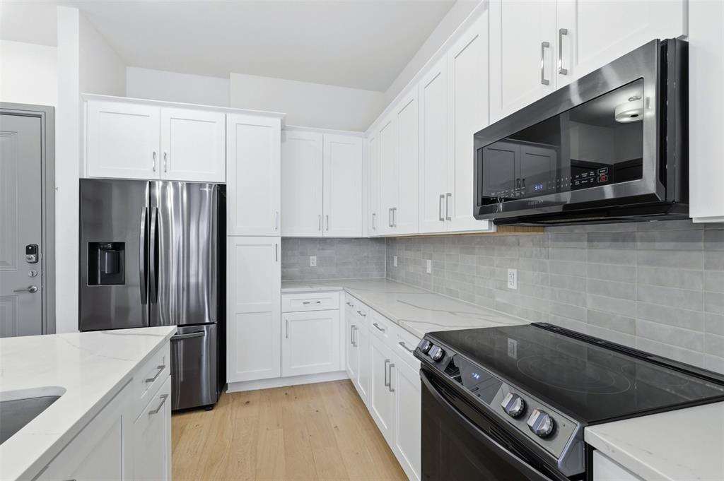 2700 Old Denton Road, Unit 1044 Carrollton, TX 75007 - Photo 11 of 39 a kitchen with stainless steel appliances a sink a stove a microwave and cabinets