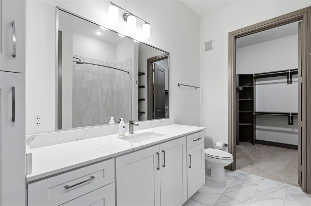 2700 Old Denton Road, Unit 1044 Carrollton, TX 75007 - Photo 14 of 39 a bathroom with a sink a toilet and a large mirror