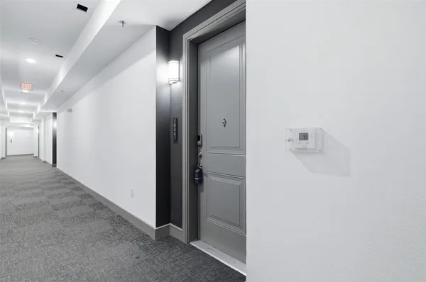 a view of a hallway with closet and bathroom