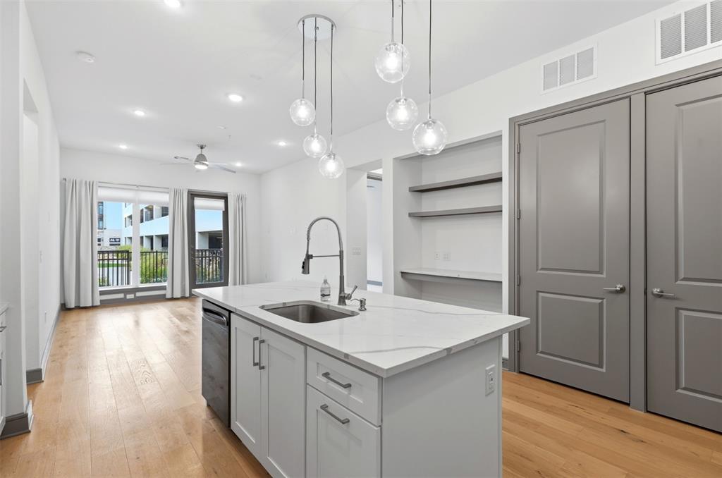 2700 Old Denton Road, Unit 1044 Carrollton, TX 75007 - Photo 7 of 39 a kitchen with a sink chandelier and wooden floor