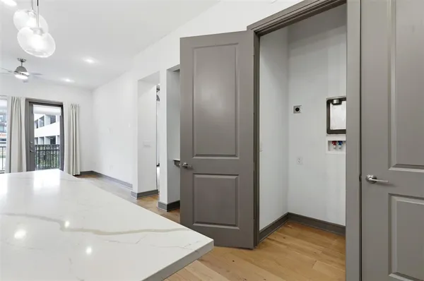 a view of an empty room with wooden floor and a bathroom