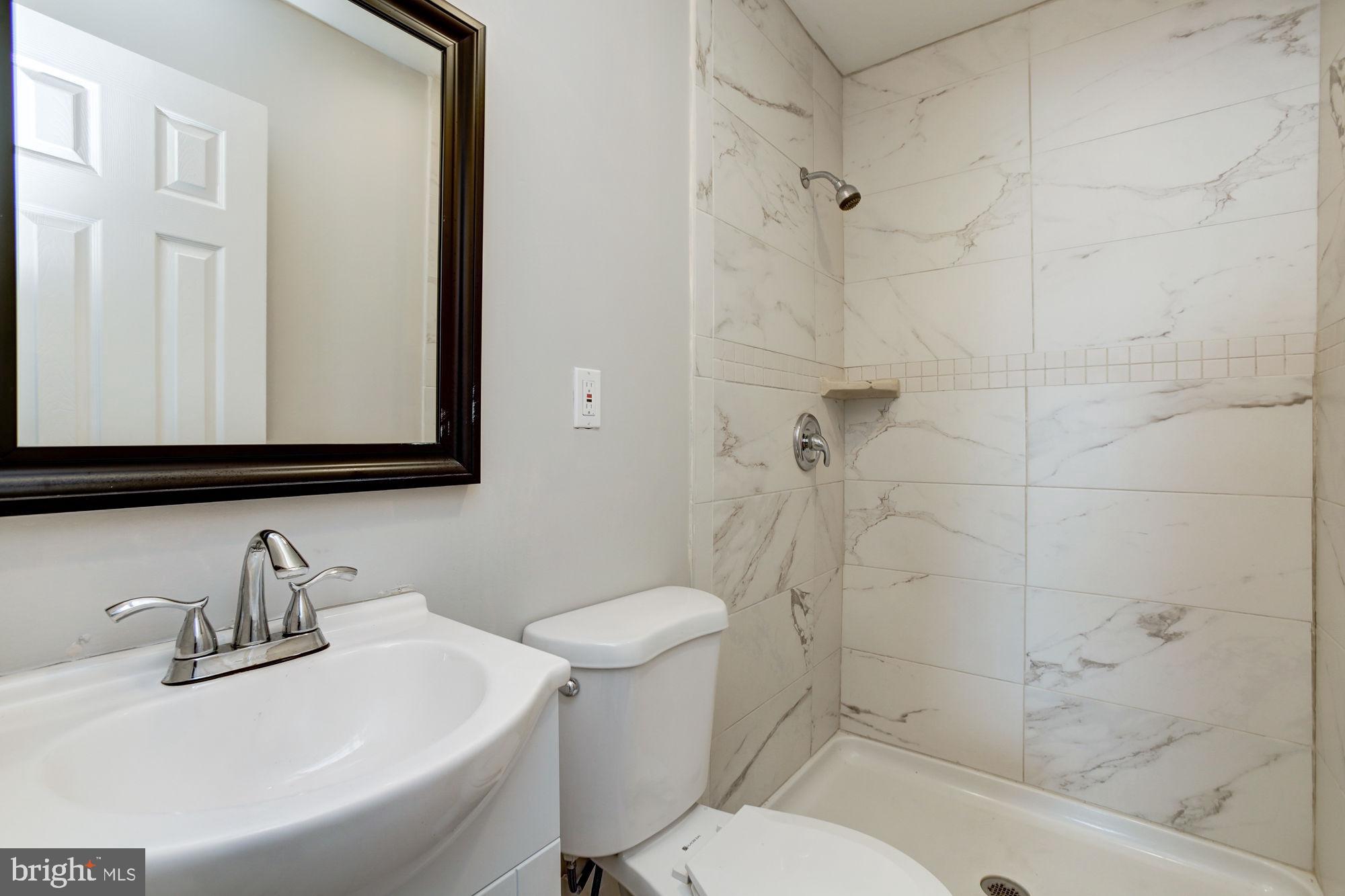 3315 Eastern Avenue, Unit 203 Baltimore, MD 21224 - Photo 11 of 13 a bathroom with a sink toilet and shower