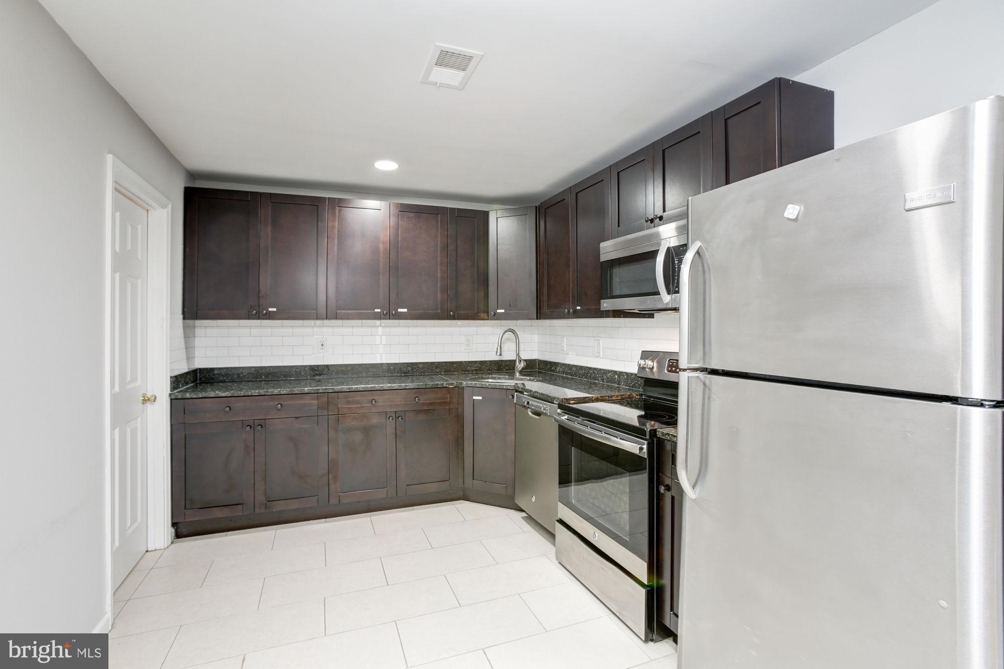 3315 Eastern Avenue, Unit 203 Baltimore, MD 21224 - Photo 4 of 13 a kitchen with granite countertop a refrigerator and a sink