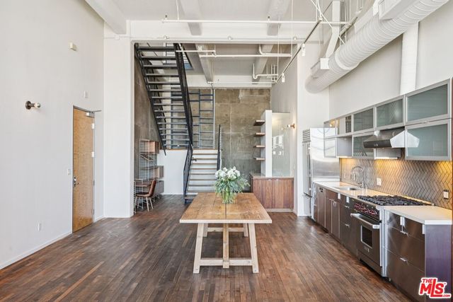 a kitchen with stainless steel appliances a stove and wooden floor