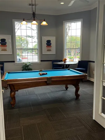 a room with pool table and windows