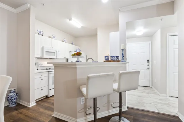a kitchen with white cabinets and appliances