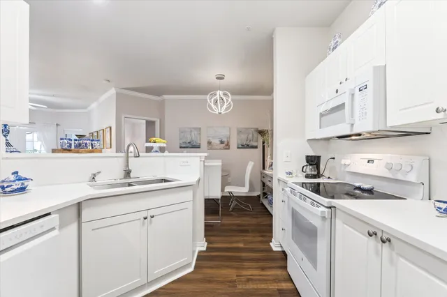 a kitchen with a sink dishwasher stove and white cabinets