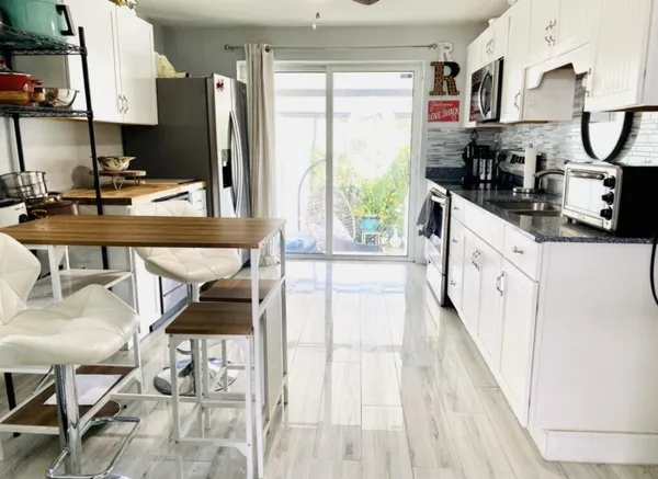 a kitchen with stainless steel appliances granite countertop a stove a sink and a microwave