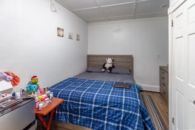 a view of a bedroom with wooden floor and furniture