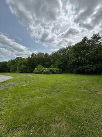 a view of a green field with wooden fence