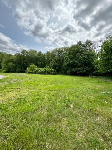 a view of a field with an trees in the background