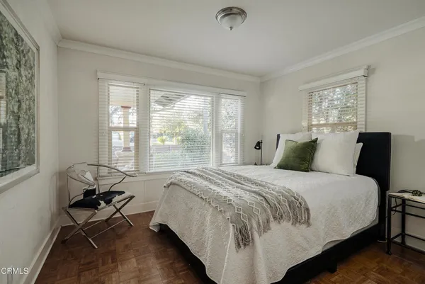 a bed sitting in a bedroom next to a window