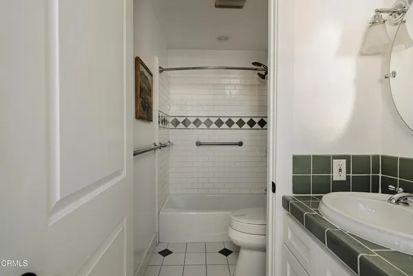 a bathroom with a granite countertop sink a toilet and shower