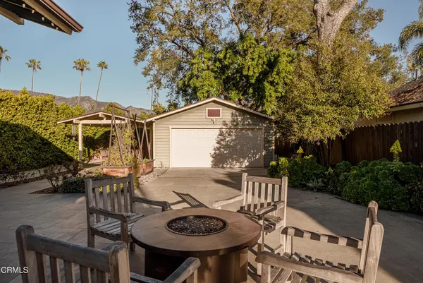 a view of a patio with table and chairs with wooden fence and plants
