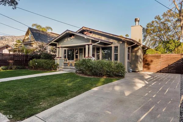 a front view of a house with a garden and plants