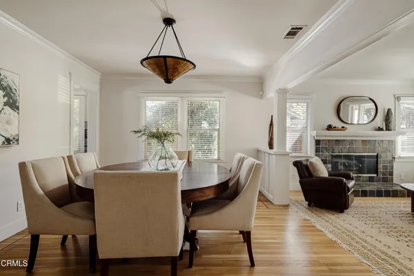 a dining room with furniture a fireplace and wooden floor