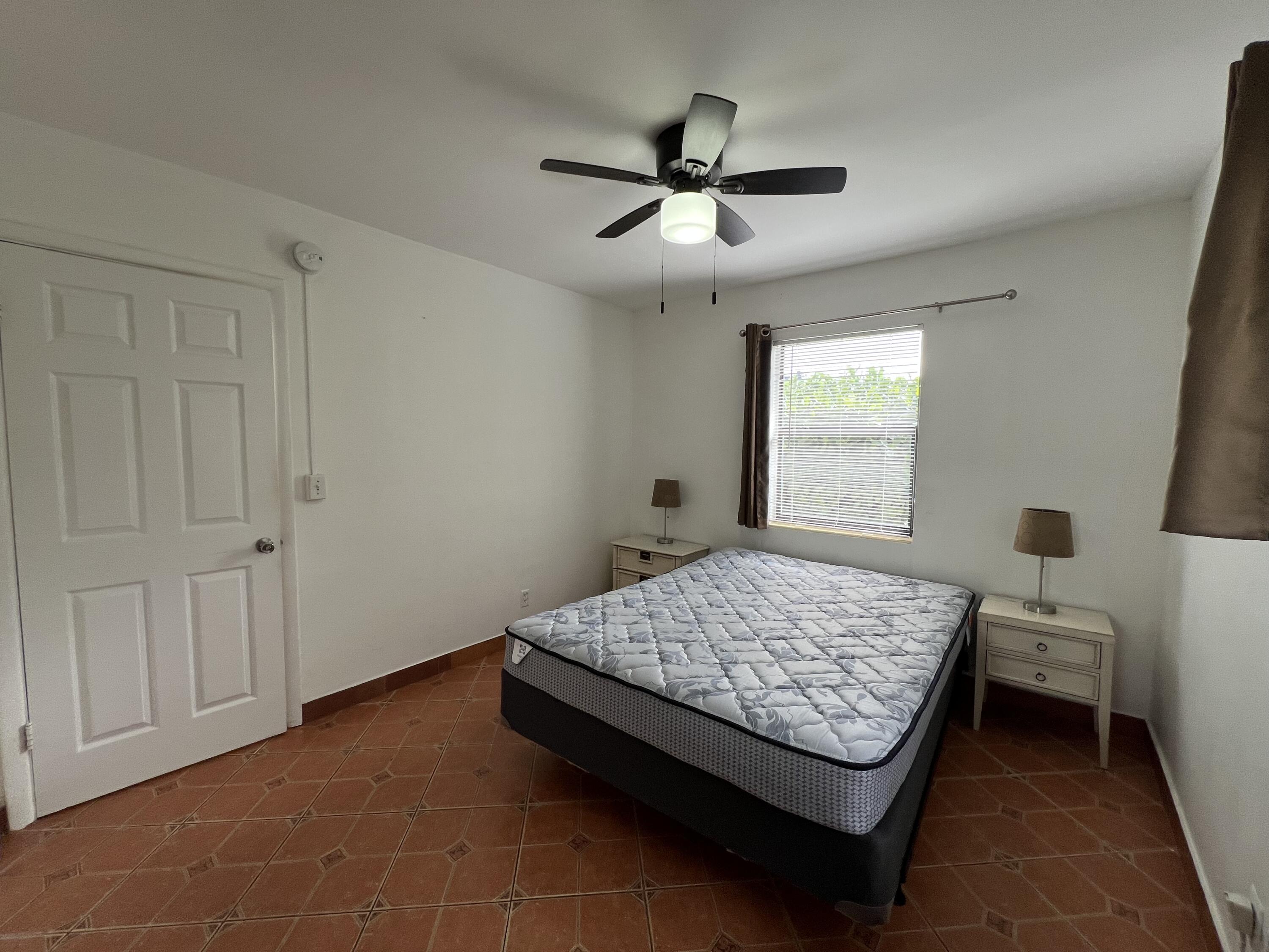 311 Inlet Way, Unit 11 Palm Beach Shores, FL 33404 - Photo 14 of 21 a bedroom with a bed and window