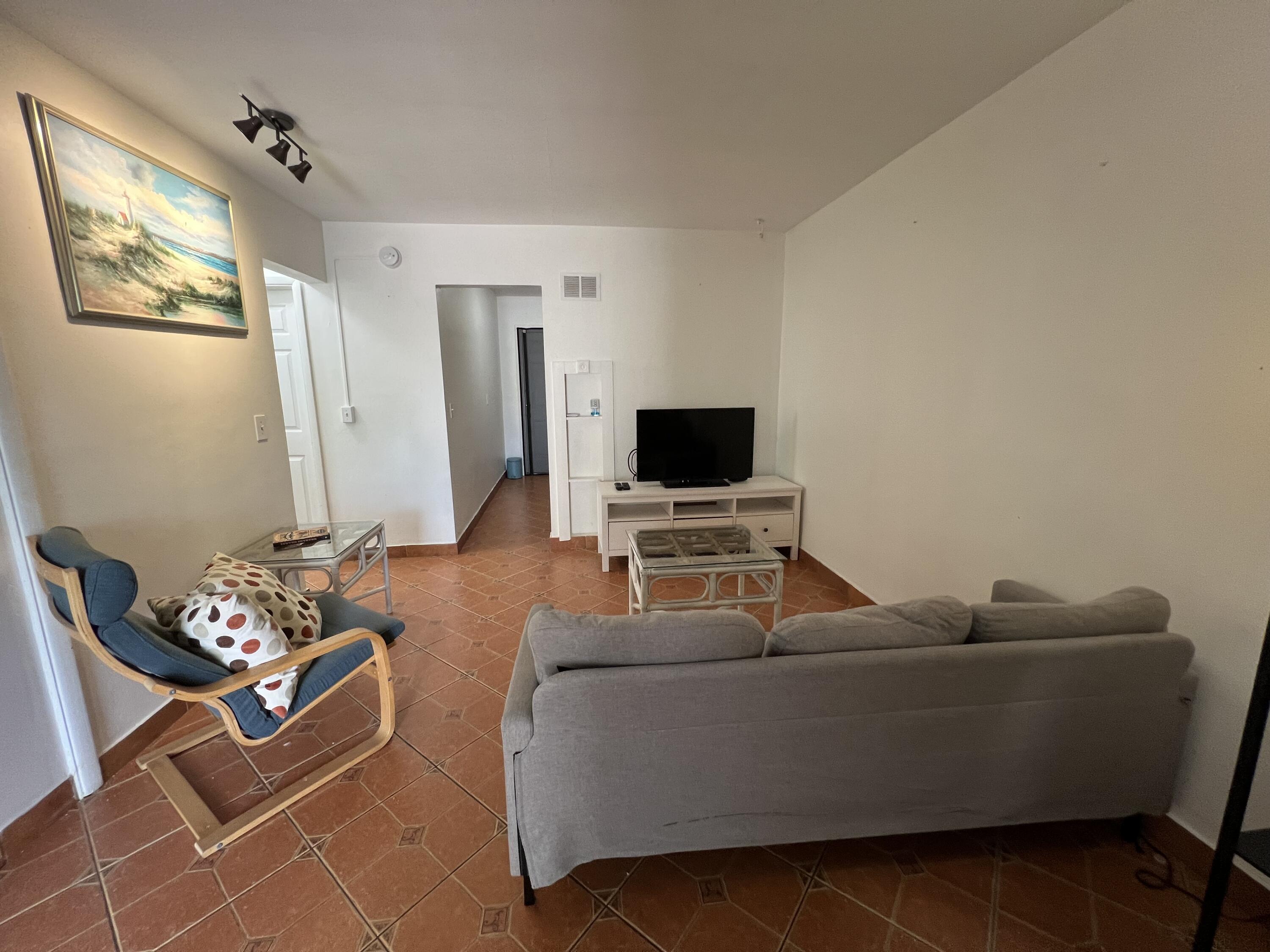 311 Inlet Way, Unit 11 Palm Beach Shores, FL 33404 - Photo 7 of 21 a living room with furniture and a flat screen tv