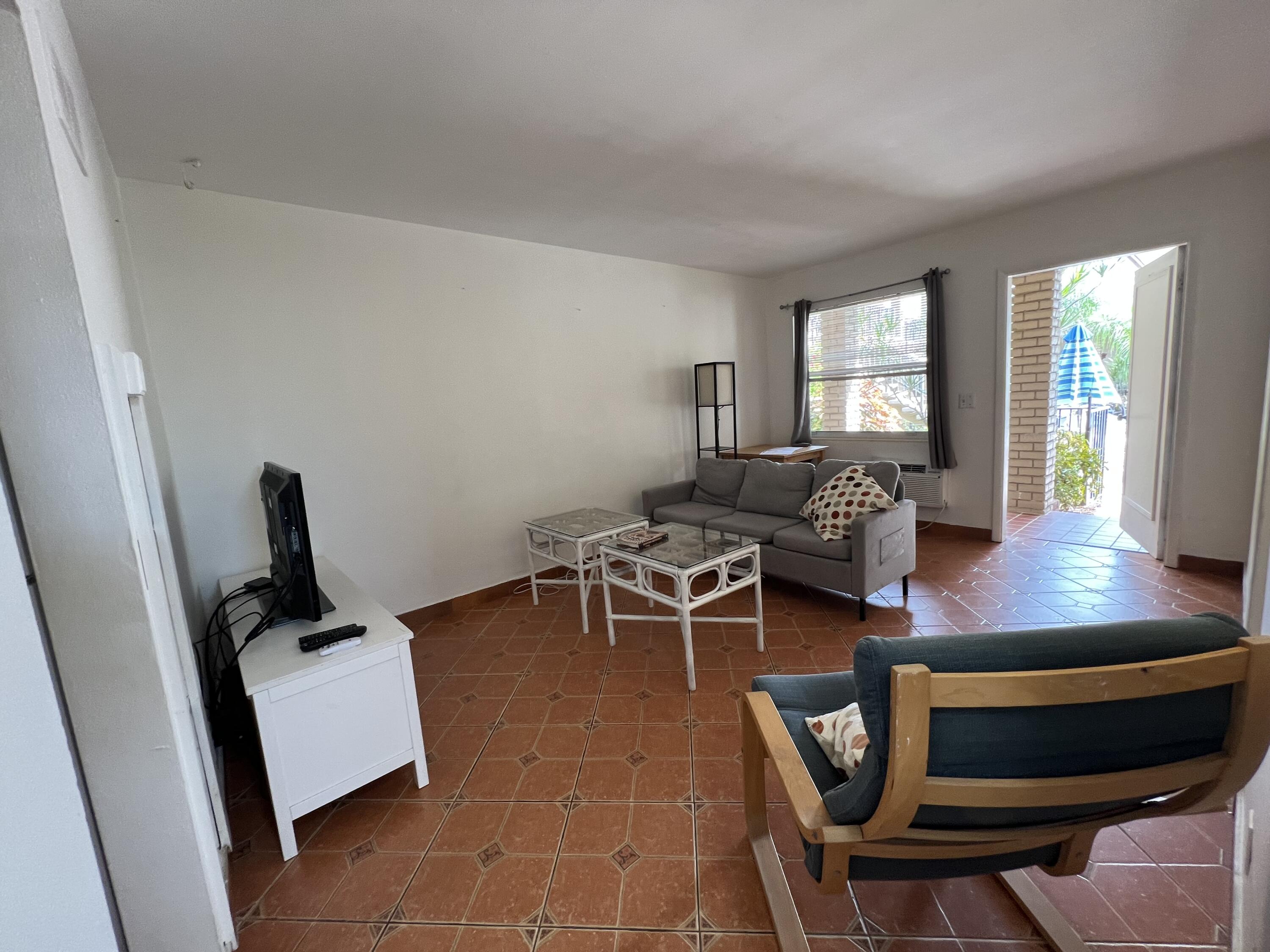 311 Inlet Way, Unit 11 Palm Beach Shores, FL 33404 - Photo 10 of 21 a living room with furniture a rug and a window