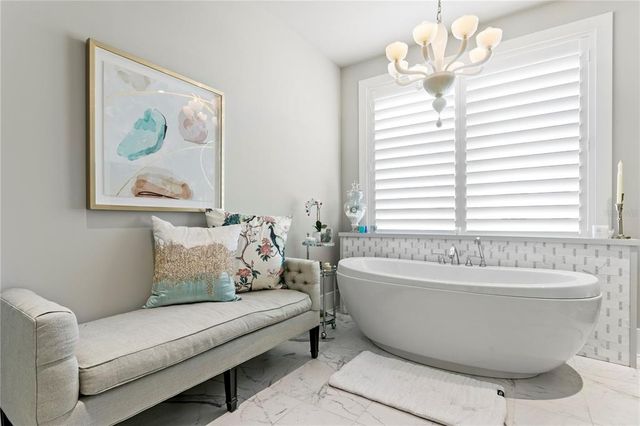 a living room with furniture a flat screen tv and kitchen view