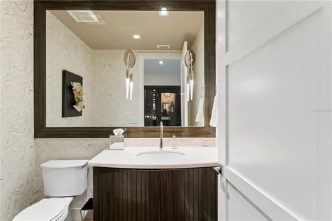 a bedroom with a large bed couch and windows