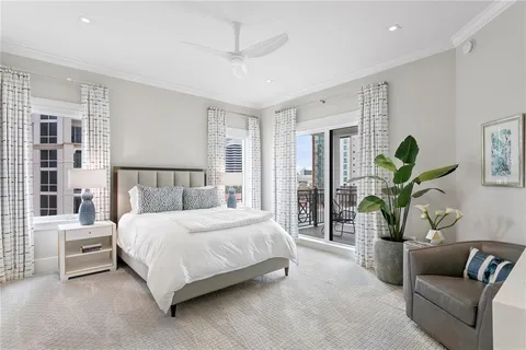 a living room with stainless steel appliances furniture a rug and a kitchen view