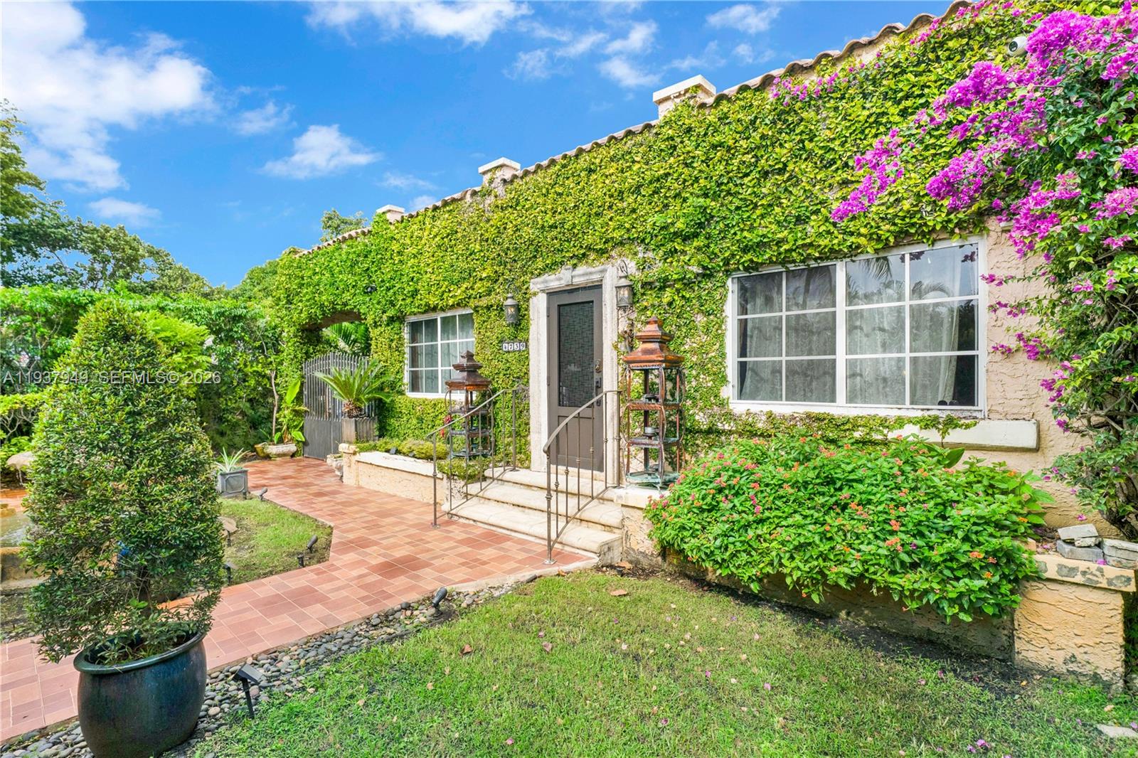 4739 Southwest 5th Street Miami, FL 33134 - Photo 21 of 40 a front view of a house with a yard and potted plants