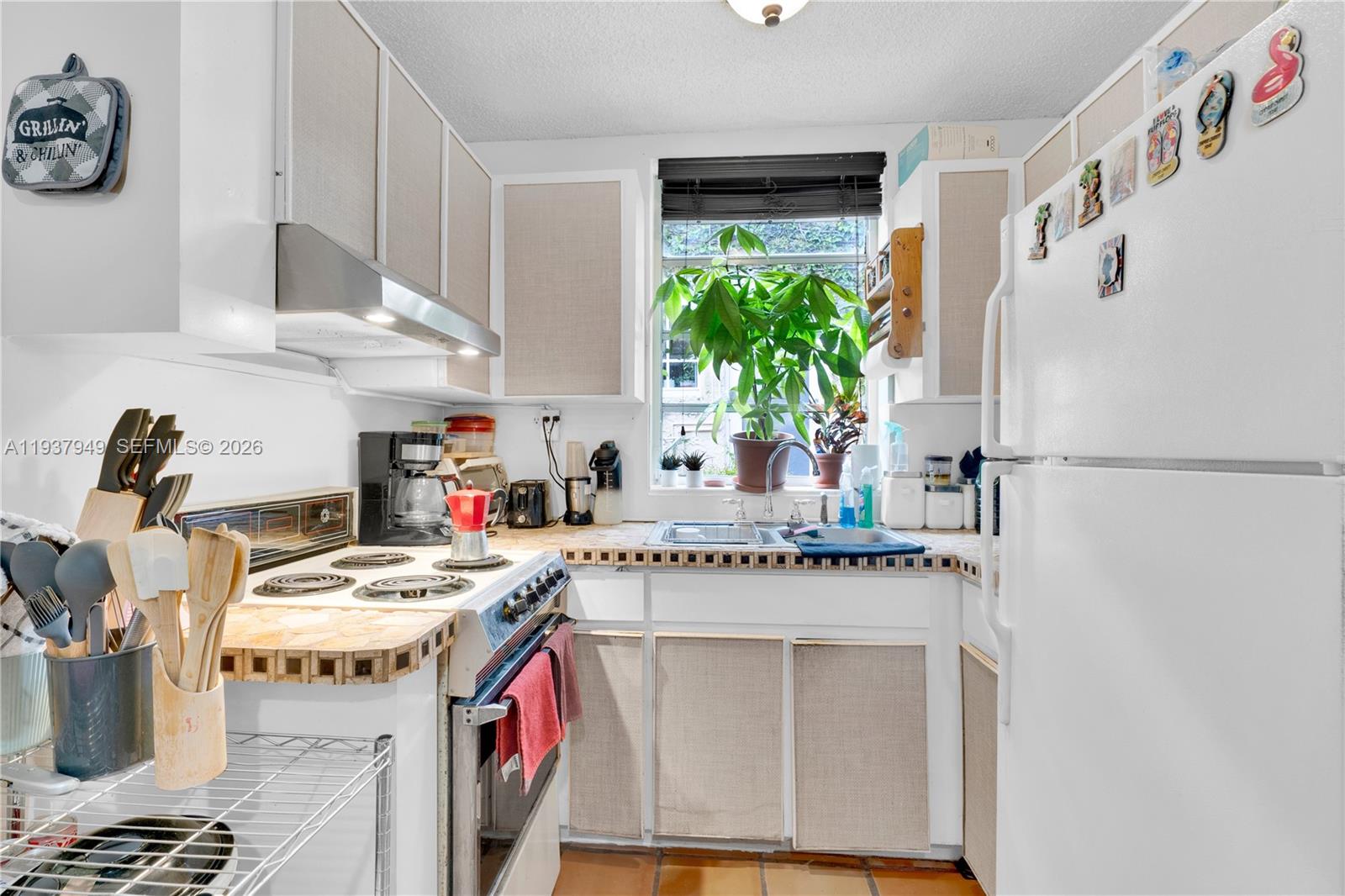 4739 Southwest 5th Street Miami, FL 33134 - Photo 31 of 40 a utility room with stainless steel appliances granite countertop a sink and a refrigerator